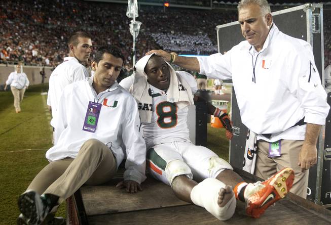 Miami running back Duke Johnson is consoled as he is taken off the field after injuring his foot during the third quarter of an NCAA college football game against Florida State on Saturday, Nov. 2, 2013, in Tallahassee, Fla. 