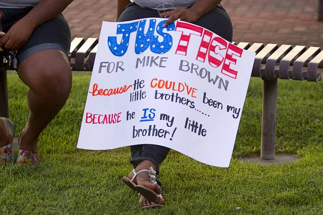 A woman holds a sign as she waits for a vigil for Michael Brown at Martin Luther King Boulevard and Carey Avenue Thursday, August 28, 2014. Brown, 18, was shot and killed by a police officer Aug. 9, 2014 in Ferguson, Mo.