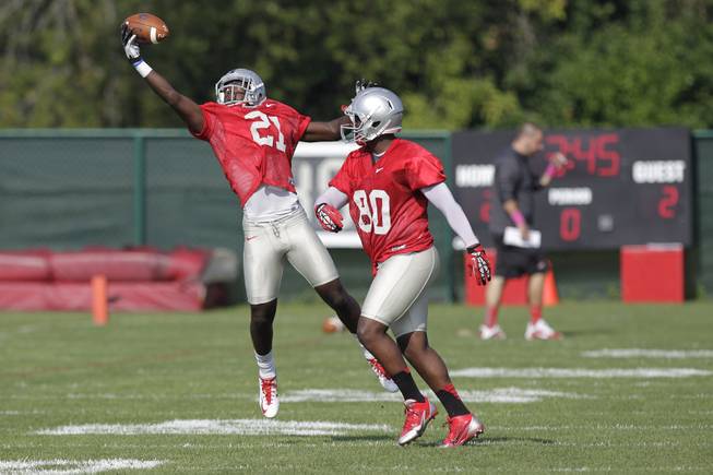 Ohio State wide receiver Parris Campbell, left, reaches for a ball as wide receiver Chris Fields defends during an NCAA college football practice Saturday, Aug. 9, 2014, in Columbus, Ohio. 