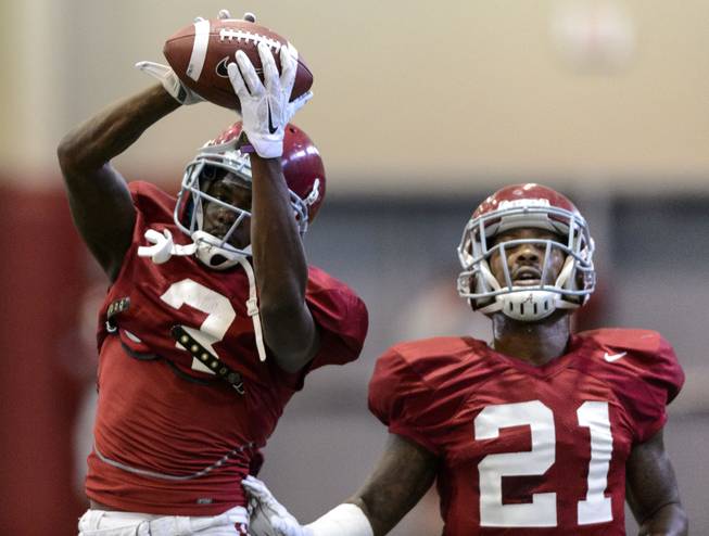 Alabama defensive back Bradley Sylve (3) grasps the ball during interception drills next to defensive back Maurice Smith (21) in Alabama's football practice, Tuesday, Aug. 26, 2014, in Tuscaloosa, Ala. 