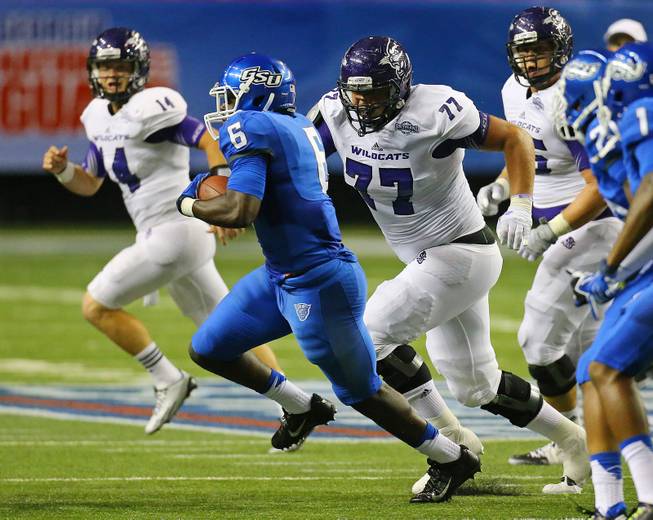Georgia State linebacker Joseph Peterson runs back an interception of a pass by Abilene Christian quarterback Parker McKenzie, left rear, during the fourth quarter of an NCAA college football game in Atlanta on Wednesday, Aug. 27, 2014. The interception set up a Georgia State touchdown drive. 