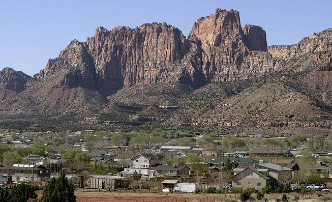 In this April 20, 2006, photo, Hildale, Utah, sits at the base of Red Rock Cliff mountains with its sister city, Colorado City, Ariz., in the foreground. 