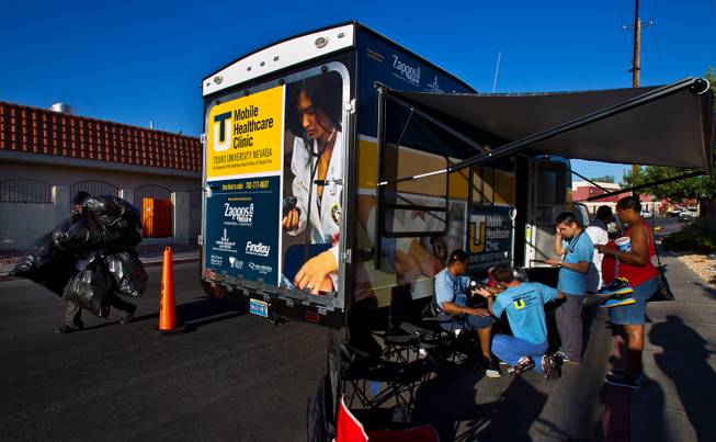 Patients begin to arrive first thing in the morning to be seen by doctors at the Touro University Nevada Mobile Healthcare Clinic parked across from Catholic Charities on Wednesday, August 27, 2014. The RV was bought and outfitted through donations and specifically serves downtown, mostly homeless individuals.