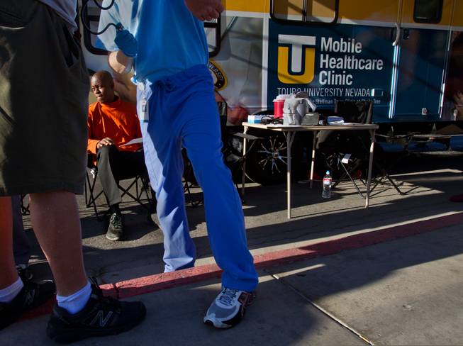 A student physician assistant takes a client's blood pressure as another patient Rene King also waits to be seen by doctors within the Touro University Nevada Mobile Healthcare Clinic parked across from Catholic Charities on Wednesday, August 27, 2014.
