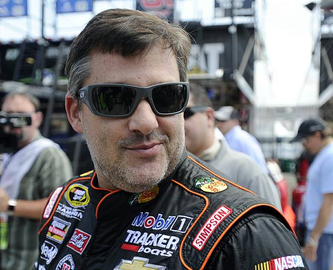 NASCAR driver Tony Stewart makes his way to his car before practicing for Sunday's auto race at Atlanta Motor Speedway in Hampton, Ga., on Friday, Aug. 29, 2014.