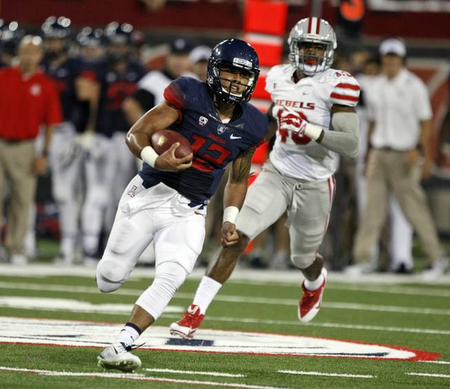 Arizona quarterback Anu Solomon (12) runs for a first down against UNLV during the first half of an NCAA college football game, Friday, Aug. 29, 2014, in Tucson, Ariz. 