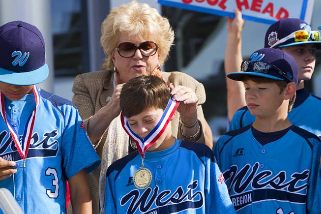 Las Vegas Mayor Carolyn Goodman hangs medals on members of the Mountain Ridge Little League team at Las Vegas City Hall Saturday, Aug. 30, 2014. After the ceremony, the team boarded an open-air Big Bus for a police-escorted parade down the Las Vegas Strip.