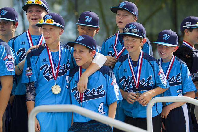 Members of the Mountain Ridge Little League team listen to coach Bob Kryszczuk during a ceremony at Las Vegas City Hall Saturday, Aug. 30, 2014. After the ceremony, the team boarded an open-air Big Bus for a police-escorted parade down the Las Vegas Strip.