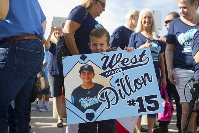 Leif Colvin holds a sign for third baseman Dillon Jones during a ceremony honoring the Mountain Ridge Little League team at Las Vegas City Hall Saturday, Aug. 30, 2014. After the ceremony, the team boarded an open-air Big Bus for a police-escorted parade down the Las Vegas Strip.