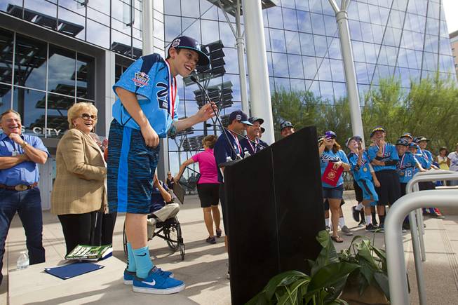 Second baseman Drew Laspaluto stands on a wall in order to reach the microphone during a ceremony honoring the Mountain Ridge Little League team at Las Vegas City Hall Saturday, Aug. 30, 2014. After the ceremony, the team boarded an open-air Big Bus for a police-escorted parade down the Las Vegas Strip.