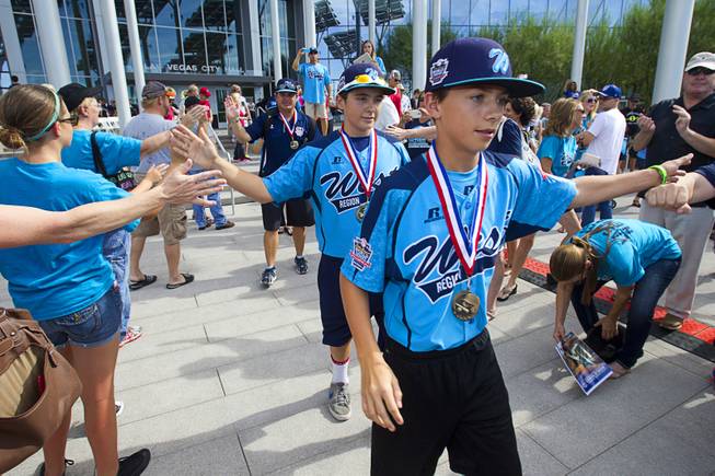Players head to a double-decker, open-air Big Bus during a ceremony honoring the Mountain Ridge Little League team at Las Vegas City Hall Saturday, Aug. 30, 2014. After the ceremony, the team boarded an open-air Big Bus for a police-escorted parade down the Las Vegas Strip.