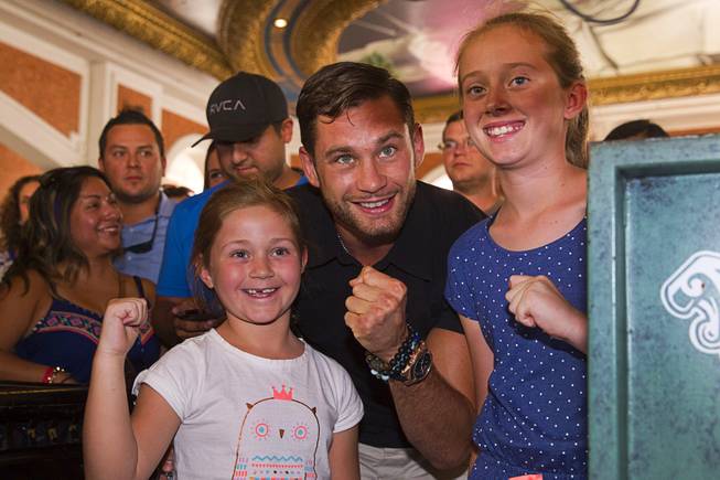 Boxer Chris Algieri of Huntington, N.Y. poses with Australian tourists Hannah Hahn, left, 7, and her sister Ebony,10, at the Venetian Saturday, Aug. 30, 2014. Algieri and Manny Pacquiao of the Philippines are on day six of an international tour promoting their WBO welterweight title fight in Macau, China on November 22, 2014.