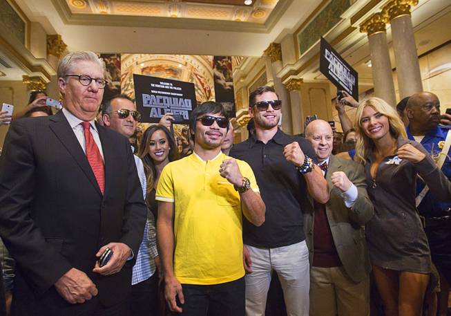 Boxers Manny Pacquiao, left, of the Philippines and Chris Algieri of Huntington, N.Y. pose in the Venetian Saturday, Aug. 30, 2014. With the boxers are Edward Tracy, left, president/CEO of Sands China, and Scott Messinger, right, corporate vice president of advertising & brand management at Las Vegas Sands. The boxers are on day six of an international tour promoting their WBO welterweight title fight in Macau, China on November 22, 2014.