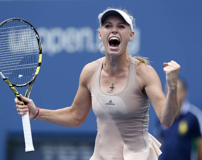 Caroline Wozniacki of Denmark reacts after defeating Maria Sharapova, of Russia, during the fourth round of the 2014 U.S. Open tennis tournament, Sunday, Aug. 31, 2014, in New York.