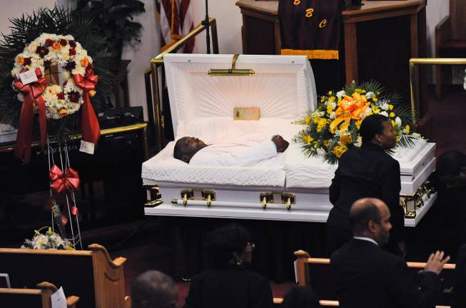 FILE - In this July 23, 2014 file photo, Eric Garner's body lies in a casket during his funeral at Bethel Baptist Church in the Brooklyn borough of New York. Garner died in police custody after an officer placed him in an apparent chokehold. Staten Island District Attorney Daniel Donovan announced Tuesday, Aug. 19, 2014, that an extra grand jury will be impaneled to hear evidence next month in the July 17 death of Garner. Donovan says his decision is based on his office's investigation and the medical examiner's ruling that the death was homicide.