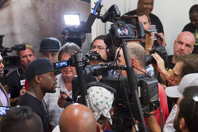 WBC/WBA welterweight champion Floyd Mayweather Jr. is surrounded by reporters and photographers during a media day at the Mayweather Boxing Club Tuesday, Sept. 2, 2014. Mayweather will face Marcos Maidana of Argentina in a rematch at the MGM Grand Garden Arena on Saturday, Sept. 13.