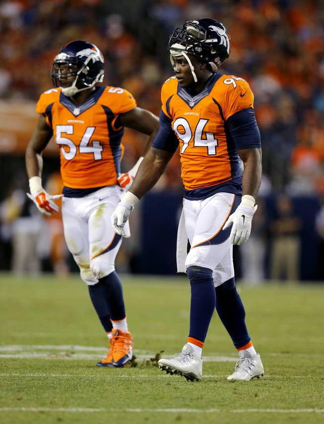 Denver Broncos defensive end DeMarcus Ware (94) and Brandon Marshall (54) walk to the bench during the first half of an NFL preseason football game against the Houston Texans, Saturday, Aug. 23, 2014, in Denver. 