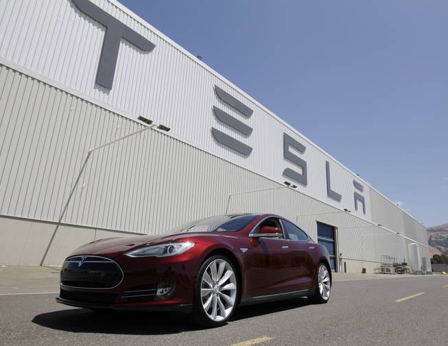 This June 22, 2012, photo shows a Tesla Model S electric sedan outside the Tesla factory in Fremont, Calif.