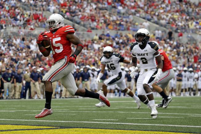  In this Aug. 30, 2014, file photo, Ohio State running back Ezekiel Elliott, left, runs past Navy safety Parrish Gaines (2) and linebacker Chris Johnson (46) for a touchdown in the second half of an NCAA college football game in Baltimore. After a 34-17 victory over Navy in the opener, coach Urban Meyer is pleased with the job done by Elliott, who gained 44 yards on 12 carries including this 10-yard touchdown run.