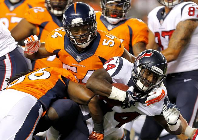 Houston Texans running back Alfred Blue (44) is tackled by Denver Broncos outside linebacker Nate Irving (56) and Brandon Marshall (54) during the first half of an NFL preseason football game, Saturday, Aug. 23, 2014, in Denver. 