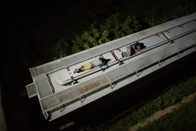 AP10ThingsToSee- In this Aug. 26, 2014 photo, Central American migrants sleep atop a moving freight train as it heads north from Arriaga toward Chahuites, Mexico. 