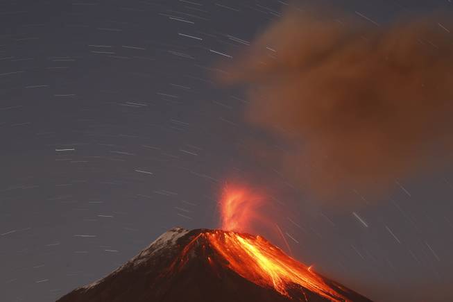 AP10ThingsToSee- The Tungurahua volcano throws ash and stones during an eruption seen from Banos, Ecuador, Sunday, Aug. 31, 2014. The volcano entered an eruptive phase in 1999 and continues to this day. 