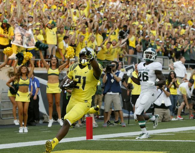 Oregon's Royce Freeman points to fans after outrunning Michigan State's R.J. Williamson into the end zone in the fourth quarter in Eugene, Ore., on Saturday, Sept. 6, 2014.