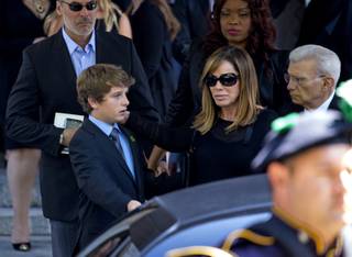 Melissa Rivers and her son Cooper Endicott walk to a waiting car after the funeral service for comedienne Joan Rivers at Temple Emanu-El in New York on Sunday, Sept. 7, 2014. Rivers died Thursday at age 81.