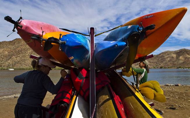Boats are unloaded from a trailer by Desert Adventures staff for a Colorado River kayak tour below the Hoover Dam on Saturday, August 30, 2014.