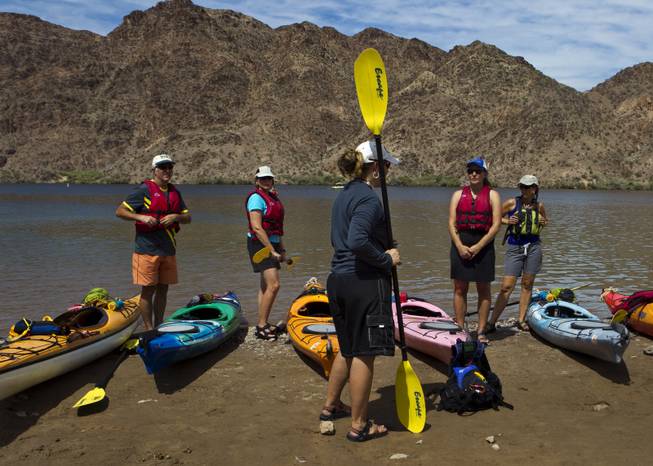 Paddlers receive last minute instructions by Desert Adventures staff member before starting a Colorado River kayak tour on Saturday, August 30, 2014