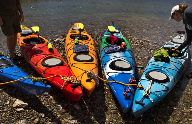Supplies are unloaded as paddlers take a short break along the Colorado River during a kayak tour with Desert Adventures on Saturday, August 30, 2014.