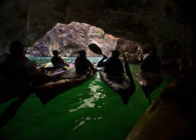 Kayakers explore a small cave along the Colorado River during a kayak tour with Desert Adventures on Saturday, August 30, 2014. 