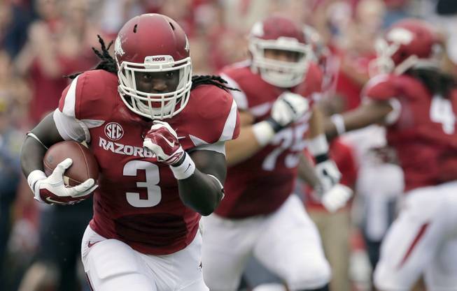 In this photo taken Sept. 6, 2014, Arkansas running back Alex Collins (3) carries in the first quarter of an NCAA college football game against Nicholls in Fayetteville, Ark. The Razorbacks, led by running backs Collins and Jonathan Williams hope to carry the momentum of Arkansas' 73-7 victory ahead to next week at Texas Tech.