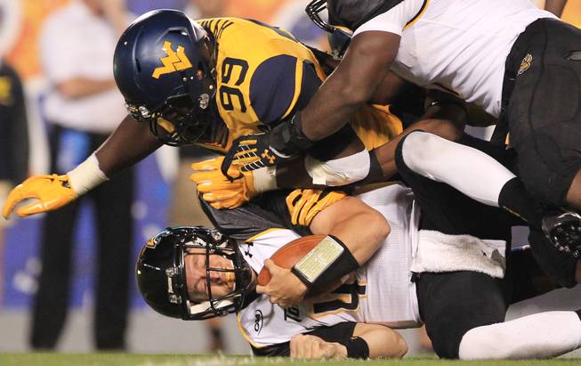 West Virginia's Dontrill Hyman (99) sacks Towson quarterback Connor Frazier (4) during the second quarter of an NCAA college football game in Morgantown, W.Va., Saturday, Sept. 6, 2014. 
