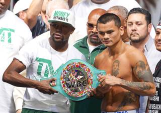 WBC/WBA welterweight champion Floyd Mayweather Jr. and Marcos Maidana stand with the WBC belt during their official weigh-in at MGM Grand Garden Arena on Friday, Sept. 12, 2014. Mayweather Jr. will defend his titles against Maidana at the arena on Saturday.