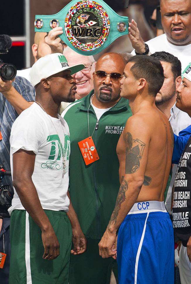 WBC/WBA welterweight champion Floyd Mayweather Jr.  and Marcos Maidana of Argentina pose during their official weigh-in at the MGM Grand Garden Arena  Friday, Sept. 12, 2014. Mayweather Jr. will defend his titles against Maidana at the arena on Saturday.