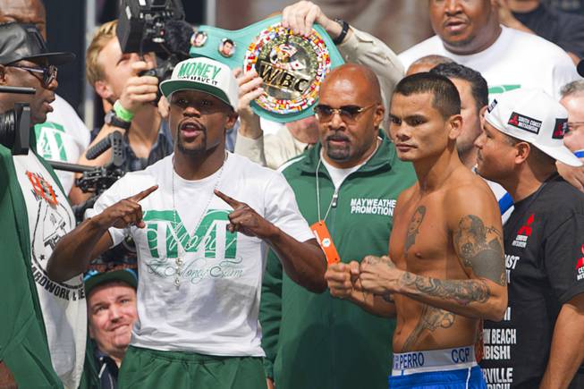 WBC/WBA welterweight champion Floyd Mayweather Jr.  and Marcos Maidana of Argentina pose during their official weigh-in at the MGM Grand Garden Arena  Friday, Sept. 12, 2014. Mayweather Jr. will defend his titles against Maidana at the arena on Saturday.