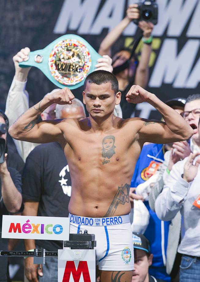 Marcos Maidana of Argentina poses on the scale during an official weigh-in at the MGM Grand Garden Arena  Friday, Sept. 12, 2014. Maidana will challenge WBC/WBA welterweight champion Floyd Mayweather Jr. for his titles at the arena on Saturday.