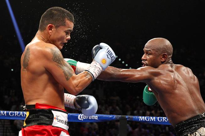 WBC/WBA welterweight champion Floyd Mayweather Jr. punches Marcos Maidana of Argentina during their title fight at the MGM Grand Garden Arena Saturday, Sept. 13, 2014.