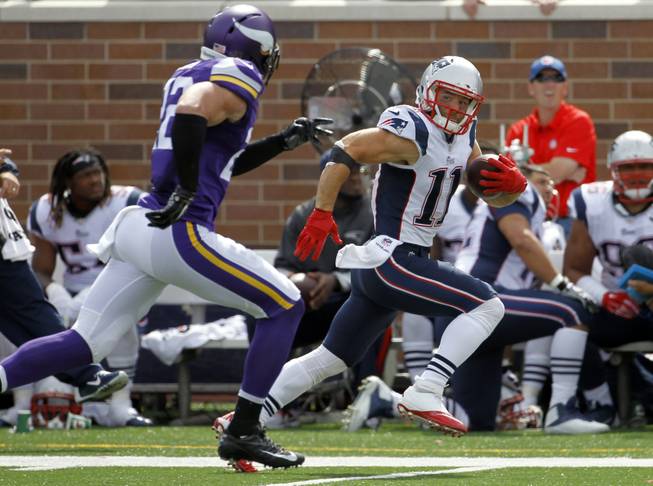 New England Patriots wide receiver Julian Edelman, right, runs with the ball past Minnesota Vikings free safety Harrison Smith after catching a pass during the second quarter of an NFL football game Sunday, Sept. 14, 2014, in Minneapolis. Edelman picked up 44 yards on the play.