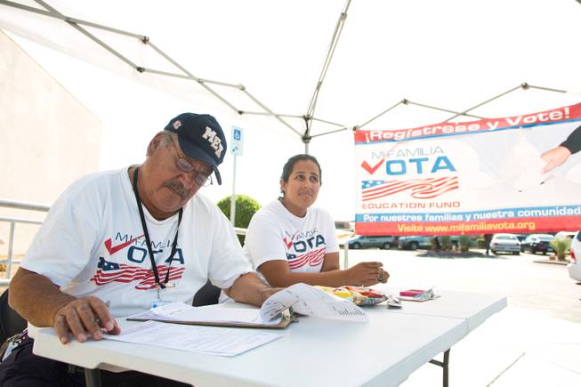 Miguel Amaral and Stephanie DeJesus attempt to register voters outside the E. Saraha DMV, Friday Sept. 12, 2014. Amaral and DeJesus are field registrars for Mi Familia Vota, a non-partisan organization that encourages civic engagement among the Hispanic community.