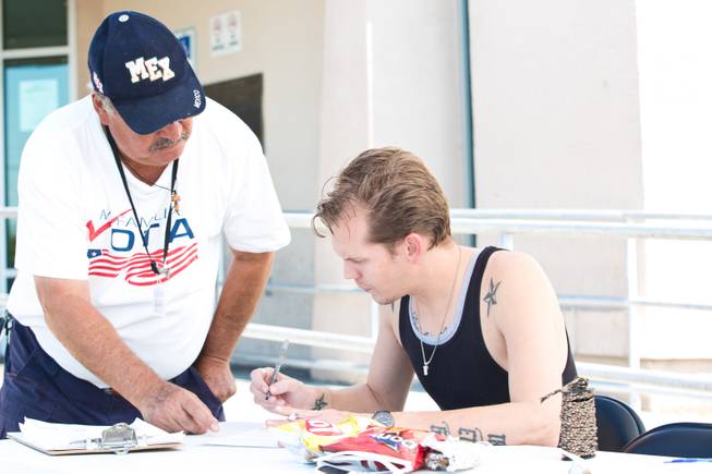 Miguel Amaral, left, helps a voter fill out a registration form outside the DMV on East Sahara Avenue, Friday, Sept. 12, 2014. Amaral is a field registrar for Mi Familia Vota, a nonpartisan organization that encourages civic engagement among the Hispanic community.