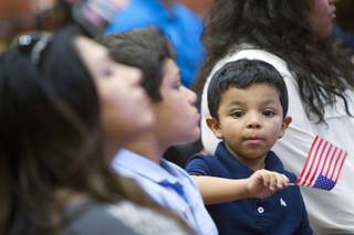 Cesar Angelo Nieto, 4, waves an American flag during a naturalization ceremony at the Historic Fifth Street School Wednesday, Sept. 17, 2014. Seventy-five people from 26 countries became naturalized U.S. citizens.