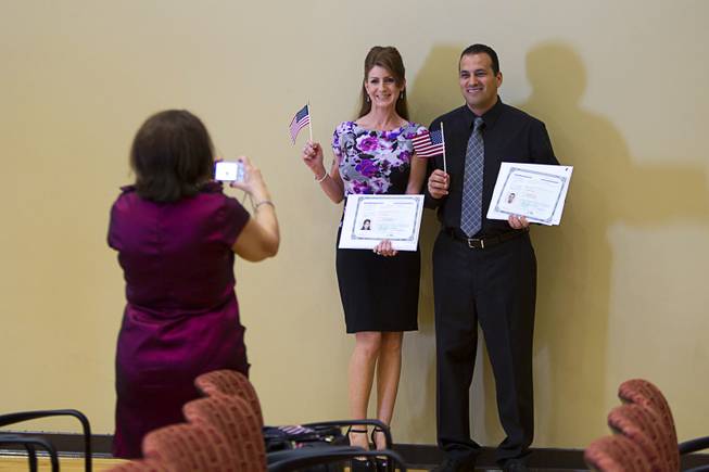 New citizens Narelle Norris, originally of Australia, and Wael Naddaf, originally of Israel, pose during a naturalization ceremony at the Historic Fifth Street School Wednesday, Sept. 17, 2014. Seventy-five people from 26 countries became naturalized U.S. citizens.