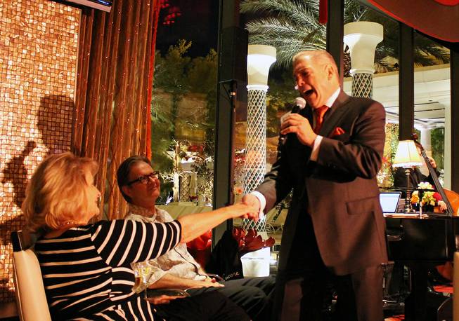 Vocalist Michael Monge is shown greeting guests during a performance at Eastside Lounge on Monday, Aug. 4, 2014, at Encore.