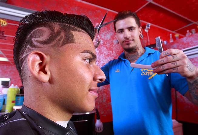 Owner Alex De La Cruz poses after giving a razor design cut to Miguel Rios, 15, at Fresh Cuts barbershop, 4533 W Sahara Ave., Thursday, Sept. 18, 2014.
