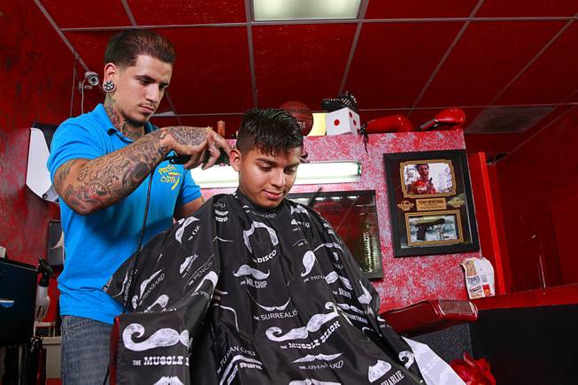Owner Alex De La Cruz prepares to give a razor design cut to Miguel Rios, 15, at Fresh Cuts barbershop, 4533 W Sahara Ave., Thursday, Sept. 18, 2014.