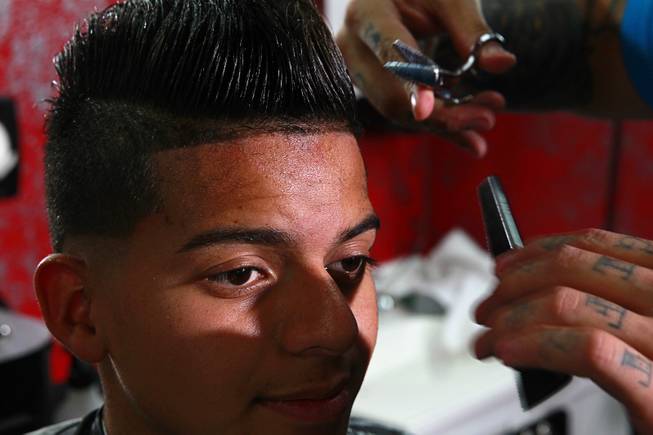 Owner Alex De La Cruz gives a cut to Miguel Rios, 15, at Fresh Cuts barbershop, 4533 W Sahara Ave., Thursday, Sept. 18, 2014.