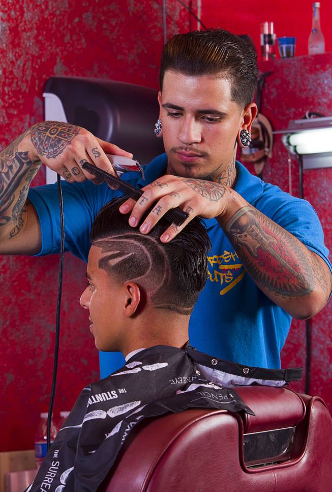 Owner Alex De La Cruz gives a razor design cut to Miguel Rios, 15, at Fresh Cuts barbershop, 4533 W Sahara Ave., Thursday, Sept. 18, 2014.