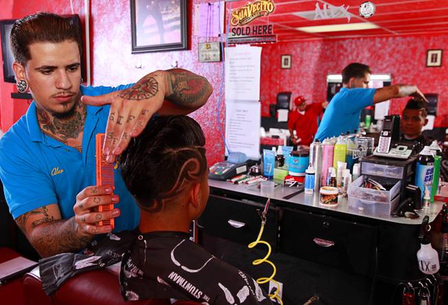Owner Alex De La Cruz gives a razor design cut to Miguel Rios, 15, at Fresh Cuts barbershop, 4533 W Sahara Ave., Thursday, Sept. 18, 2014.